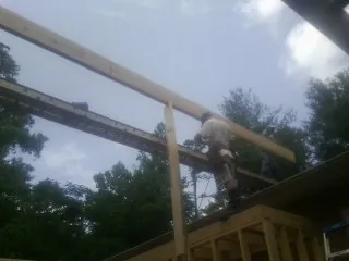 Carpenter setting a ridge beam over a new addition frame — Ice Dam Removal by Roofing Brothers in Renville