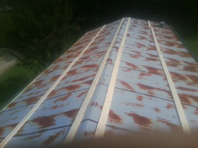 Rusted metal roof panels with new wood purlins before replacement — Storm Damage Roof Repair in Renville by Roofing Brothers
