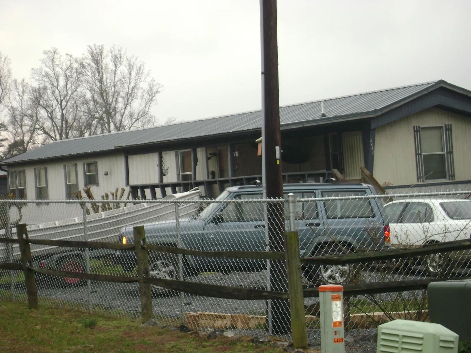 Dark metal roof on a long single story building behind a chain link fence in Renville