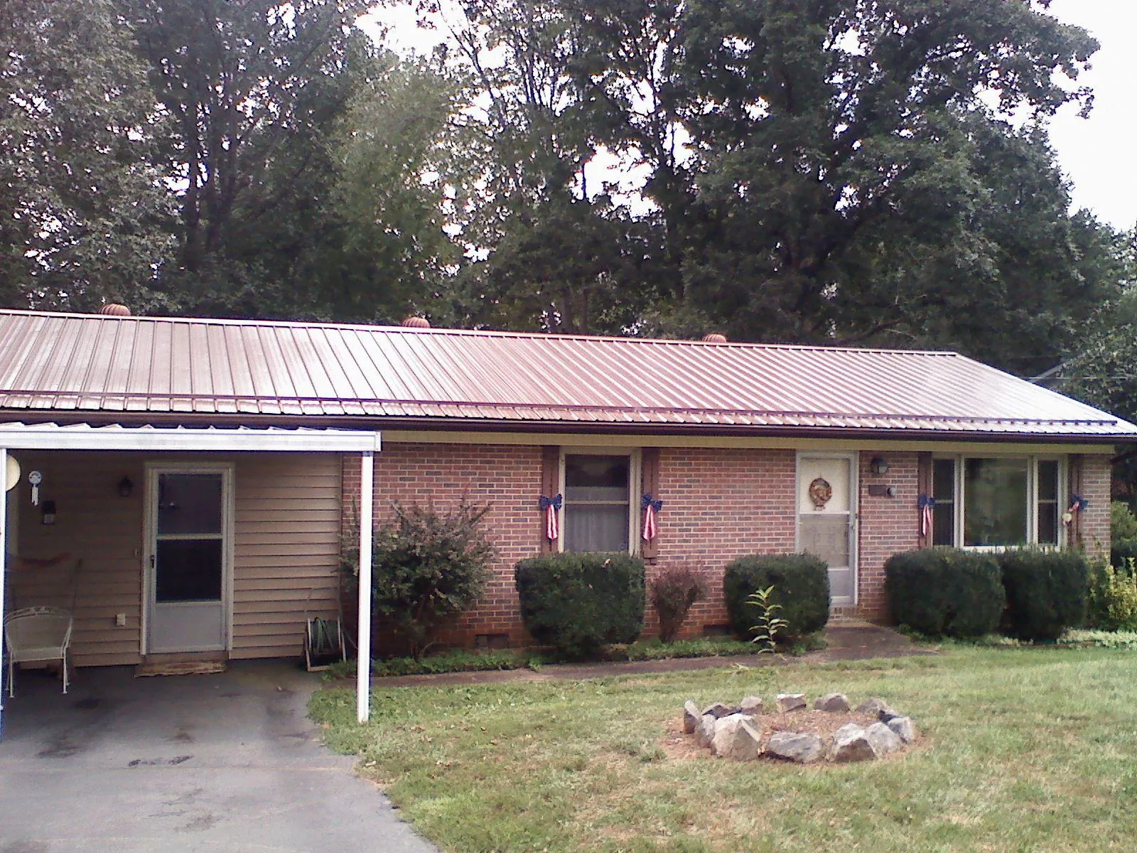 Bronze metal roof and carport on a brick ranch home — Roof Repair work by our crew in Renville